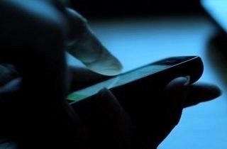 stock footage close up of woman using smartphone in dark environment her hand dimly lit by phone screen