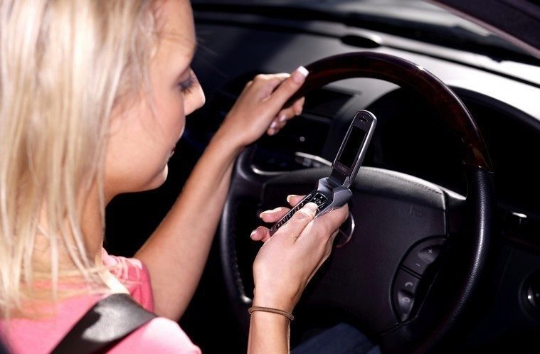 Young Woman Driving Texting on Mobile Telephone. Model Released Young Woman Driving Texting on Mobile Telephone. Model Released