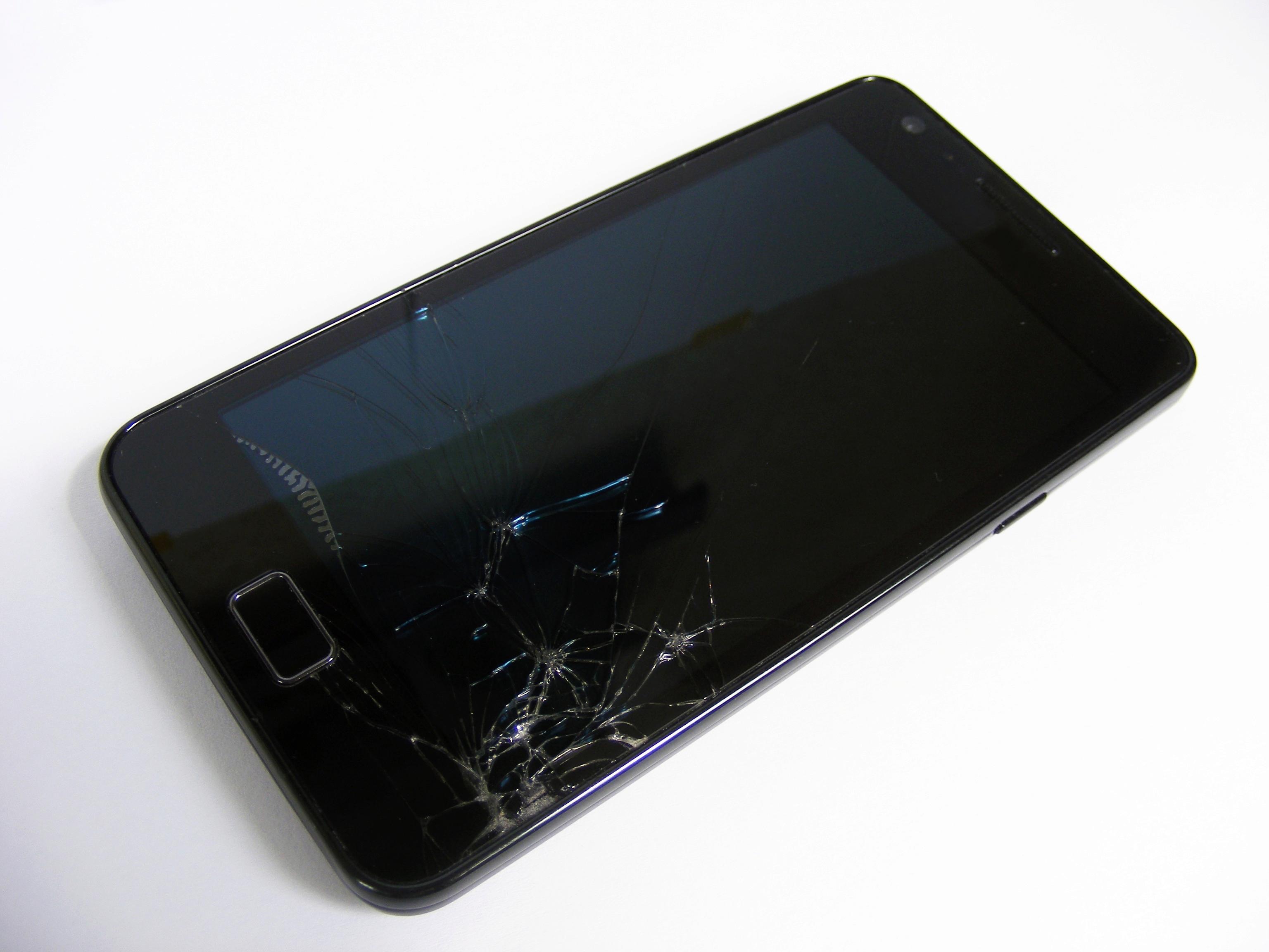 Разбитый мобильный телефон. Разбитые смартфоны. Сломанный смартфон. Смартфон с разбитым экраном. Битый дисплей смартфона.