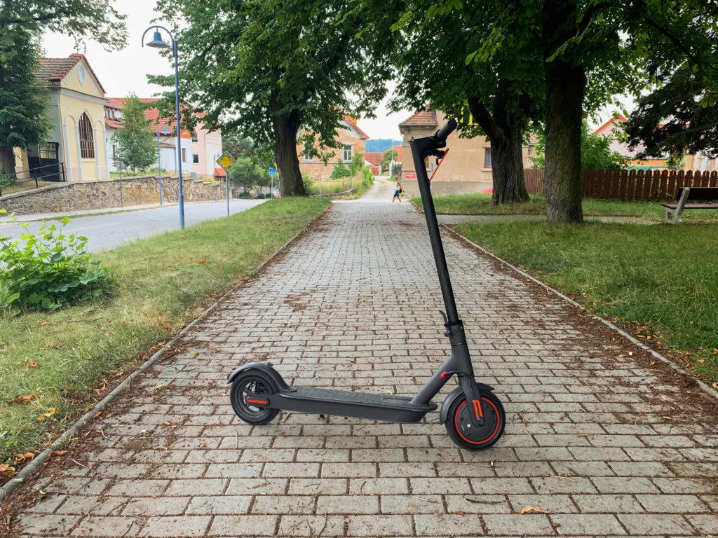 Koloběžka na chodníku Koloběžka na chodníku