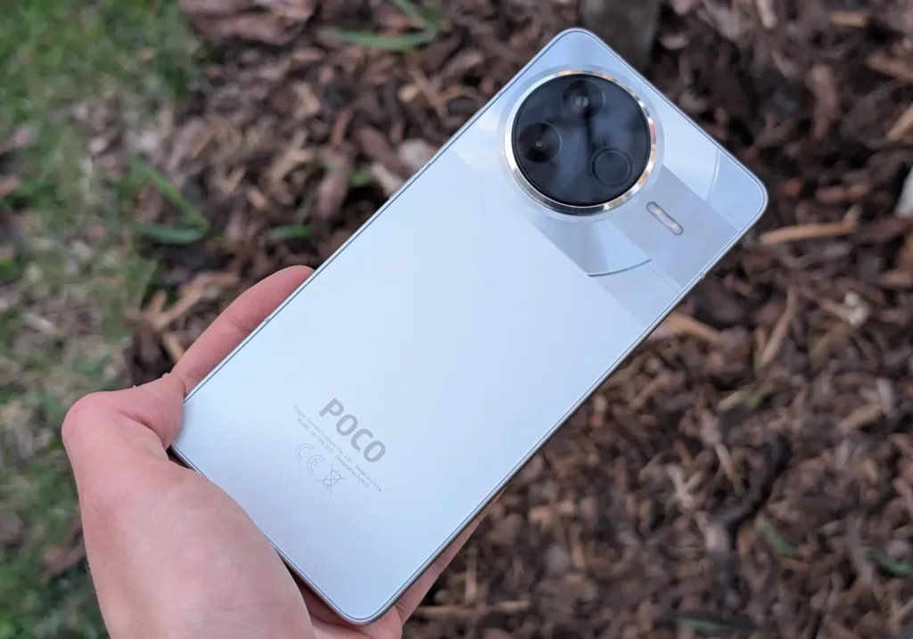 poco f7 pro zada v ruce nad drevem